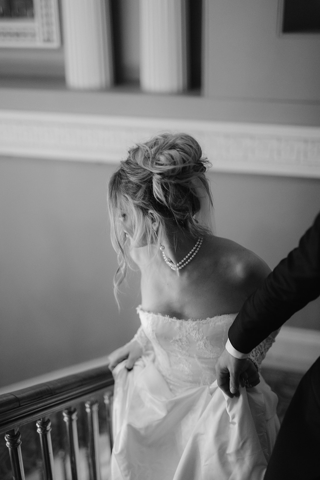 Romantic editorial portrait of a bride and groom walking up stairs.