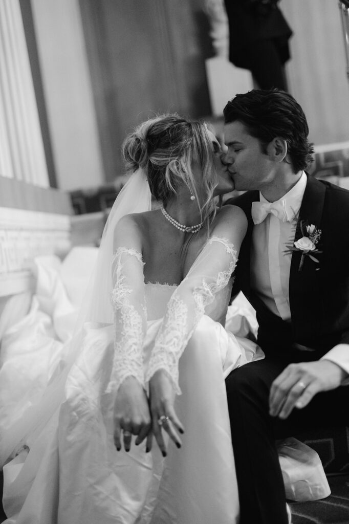 Editorial style black and white portrait of a bride and groom kissing.