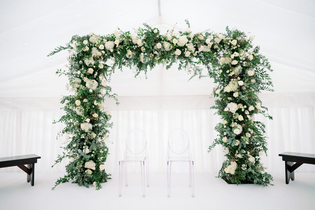 Wedding ceremony white and greenery floral arch. 