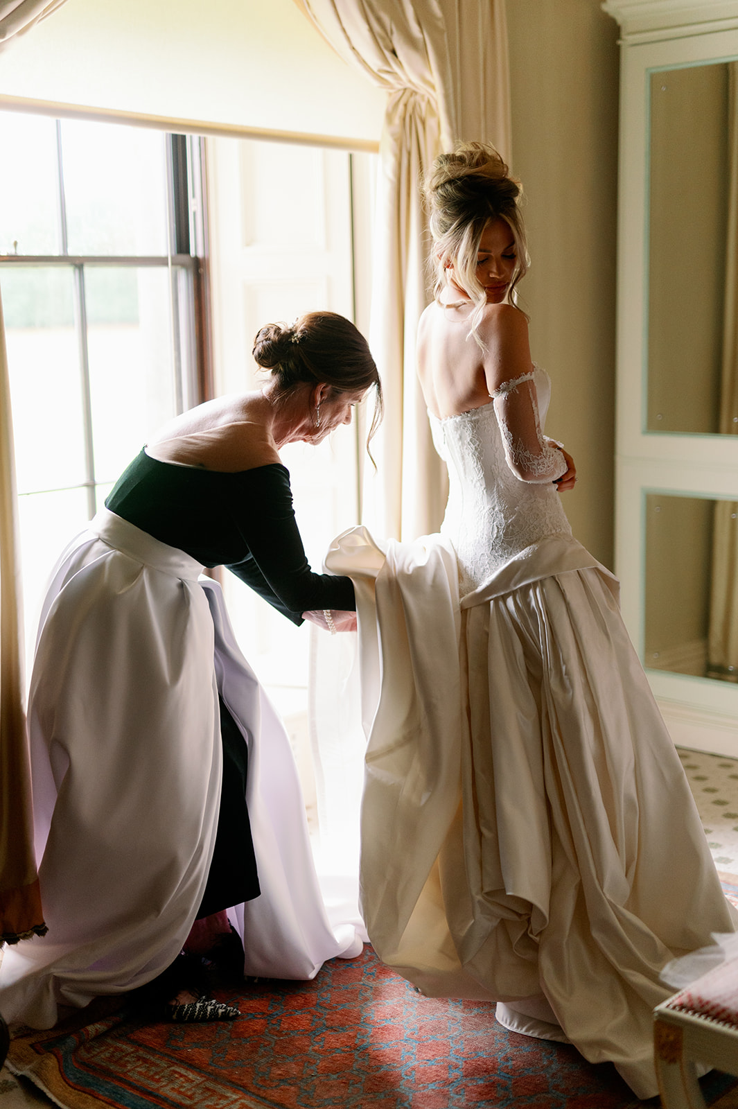 Bride getting ready with her mom in a stunning custom gown.