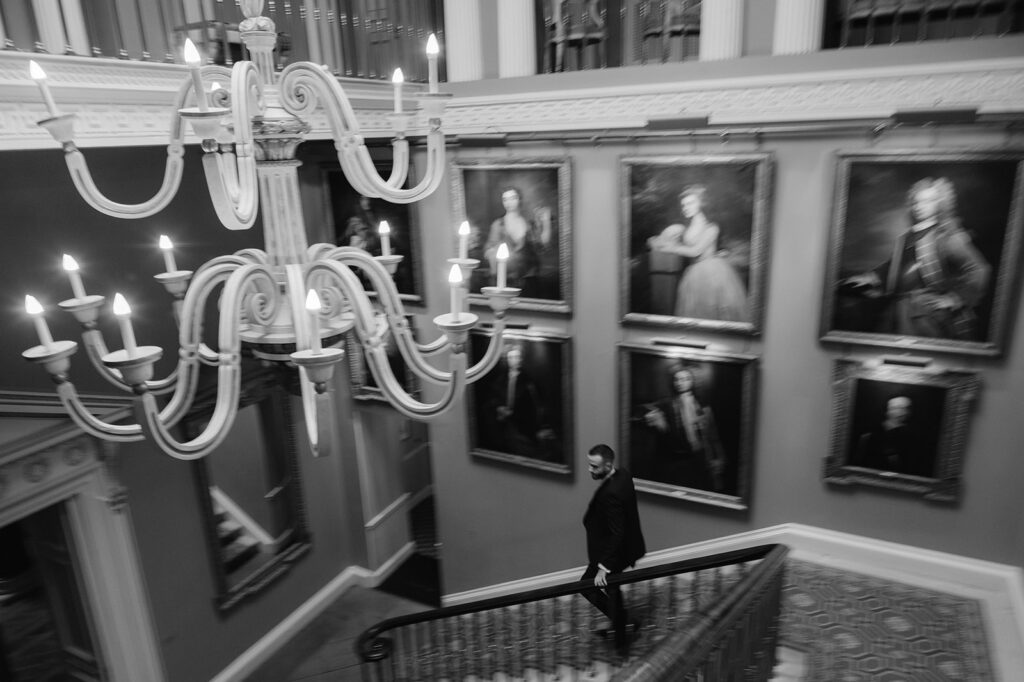 Black and white fine art image of a man walking down the stairs at Ballyfin Demesne