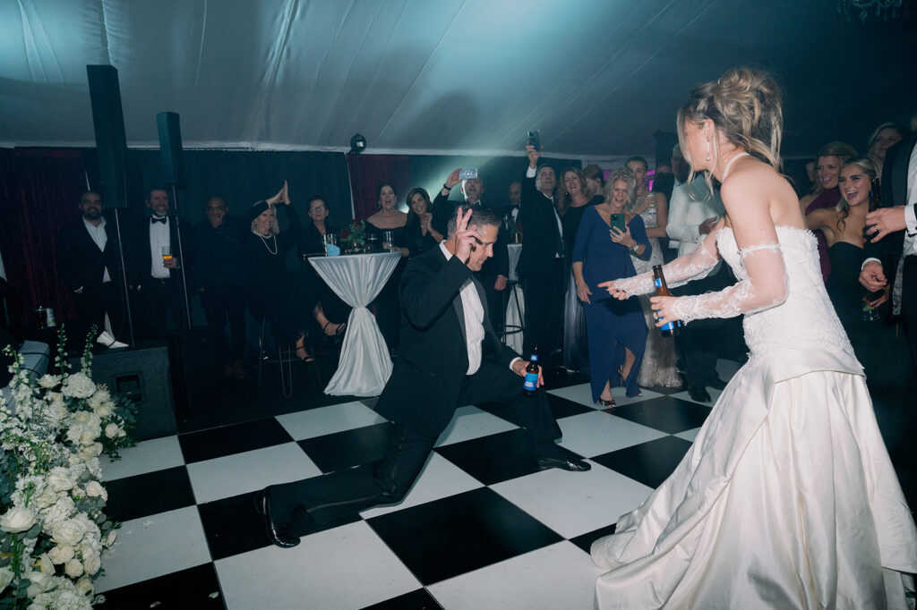 Bride and her dad dancing on a checkered dance floor.