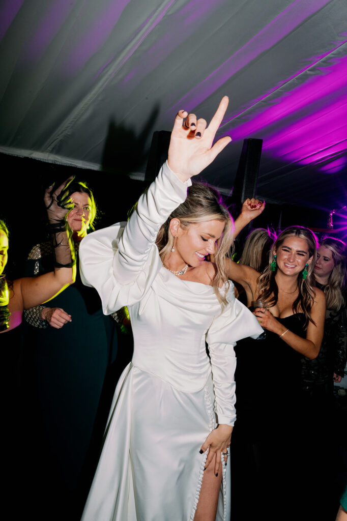 Bride dancing in a middle of a circle at her wedding reception party.