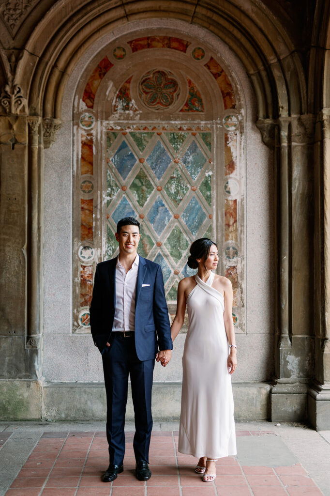 Couple standing under the iconic arches at Bethesda Terrace in Central Park. 