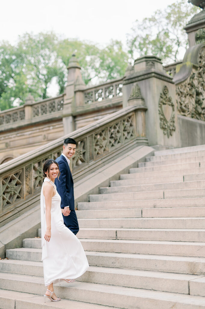 Elegant couple walking up the steps of Bethesda Terrace in New York's Central Park. 