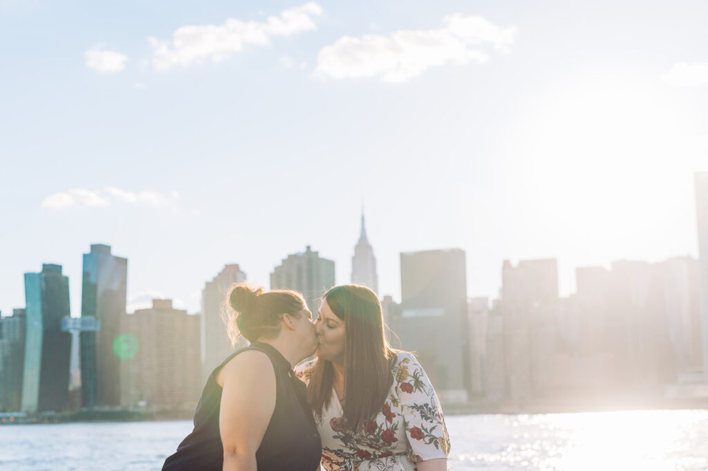 Couple kissing against a backdrop of the iconic New York City skyline in Long Island City.  