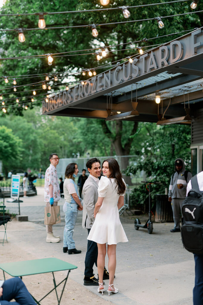 Couple standing in line at the Madison Square Park Shake Shack during their engagement photos. 