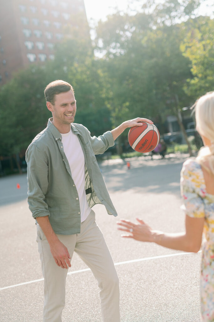 Couple playing one-on-one basketball for their NYC engagement photoshoot.
