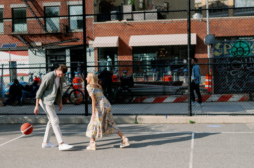 Couple dressed in nice clothes playing basketball in downtown New York City.