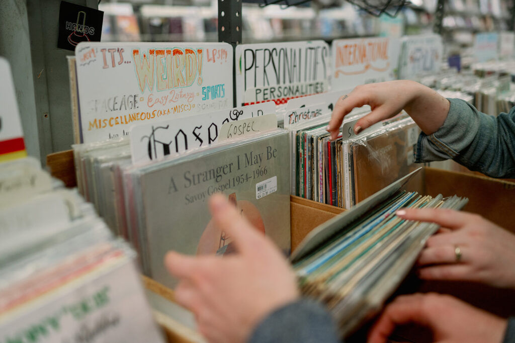 Couple flipping through vinyl records in a New York record shop.