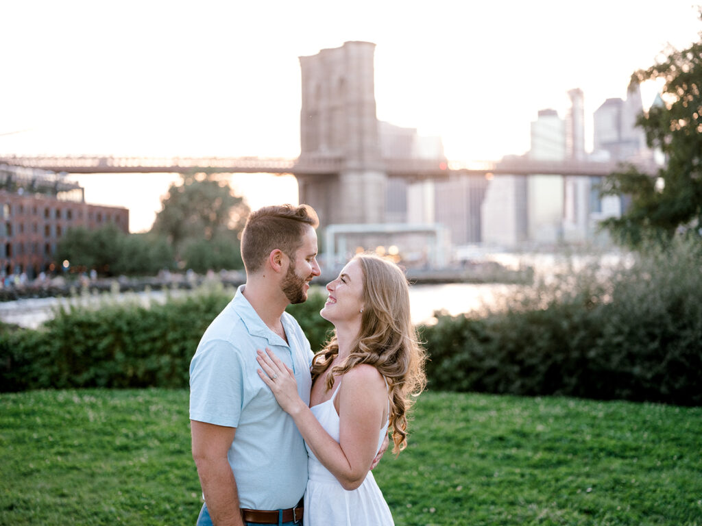 Couple looking at each other and smiling during their New York City engagement photo session. 
