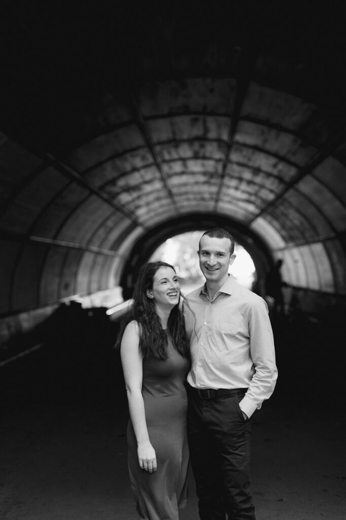 Couple posing under a tunnel in New York City's Prospect Park for their engagement photo session.