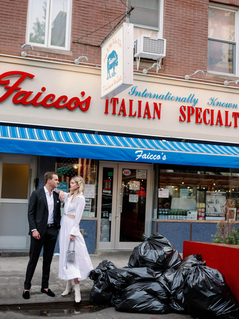 Gorgeous couple standing next to a pile of trash outside a local Italian restaurant in New York City. 