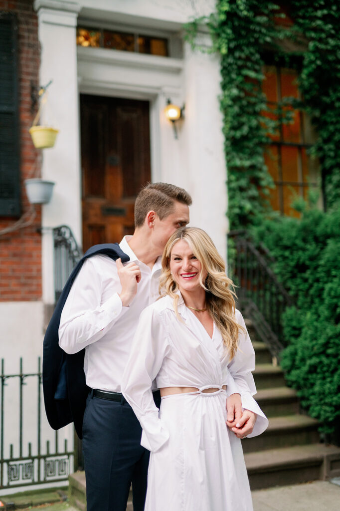 Couple standing in front of a NYC Brownstone for their romantic engagement photo session. 