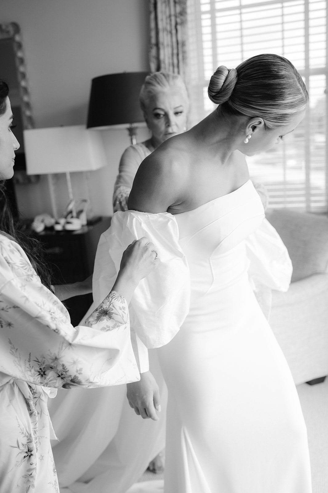 A bride putting her wedding dress on in an Ocean House suite in Rhode Island.