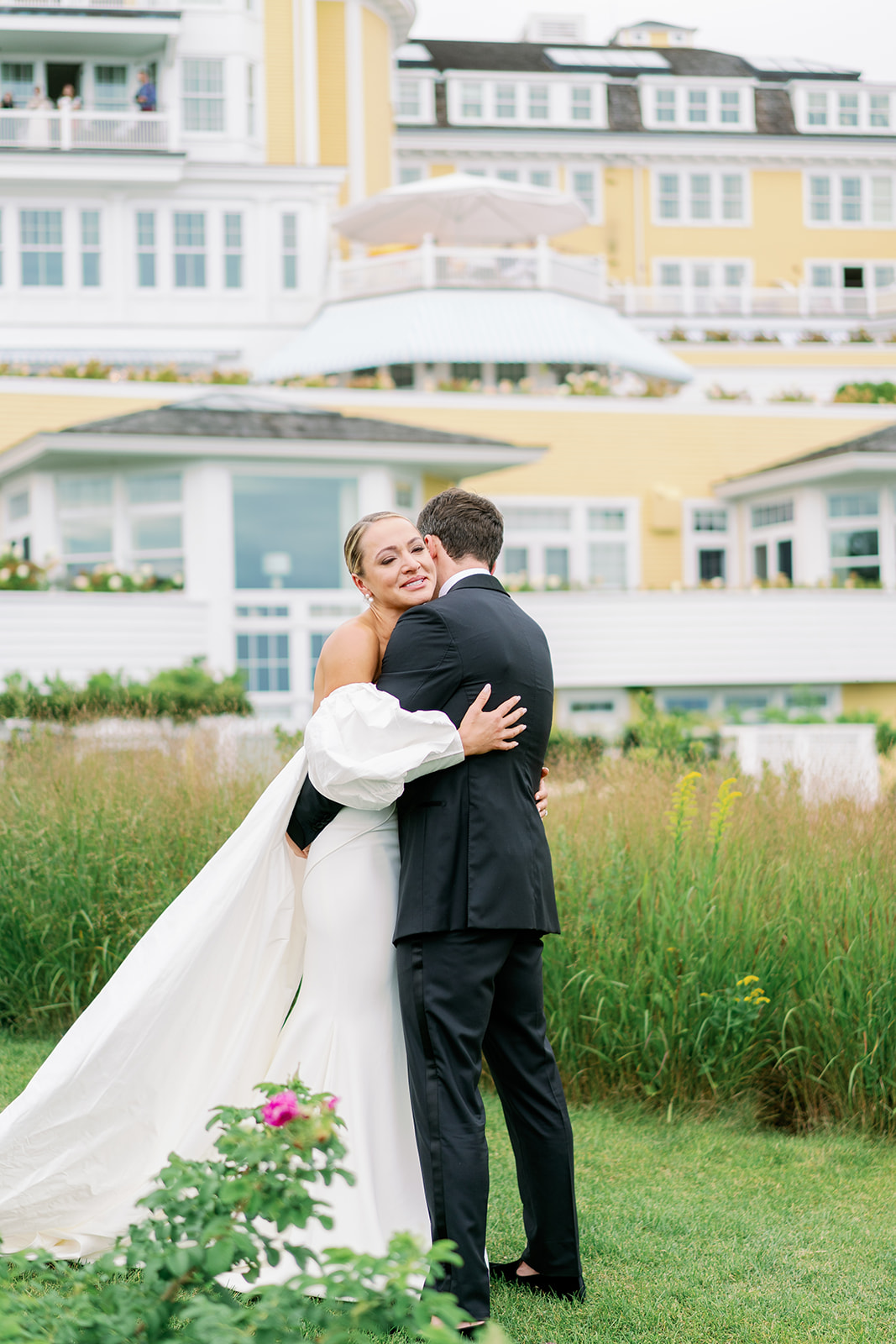 A bride and groom hugging after their first look in the garden of Ocean House in Rhode Island.