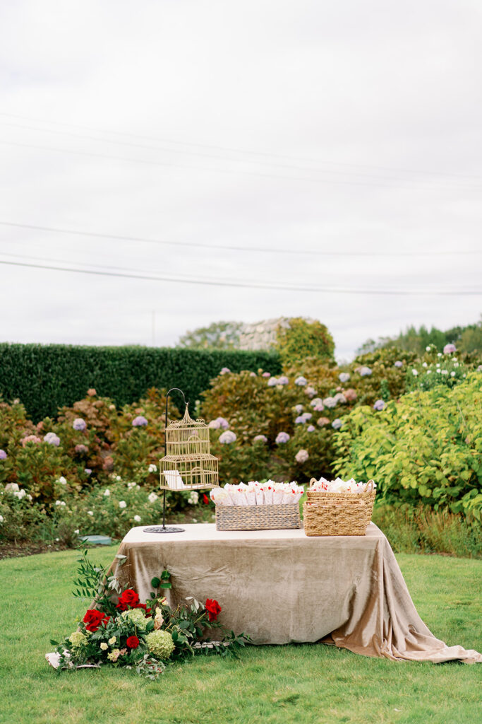 Romantic garden wedding welcome table with florals and favors.