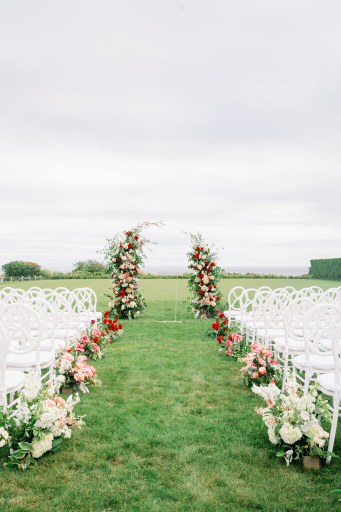 Elegant seaside floral garden wedding ceremony featuring an ombré aisle and freestanding floral arch on the lawn of Ocean House in RI. 