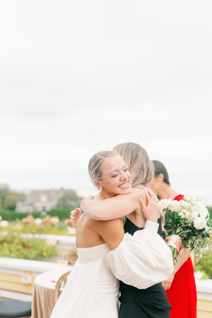 Bride hugging a guest at cocktail hour. 