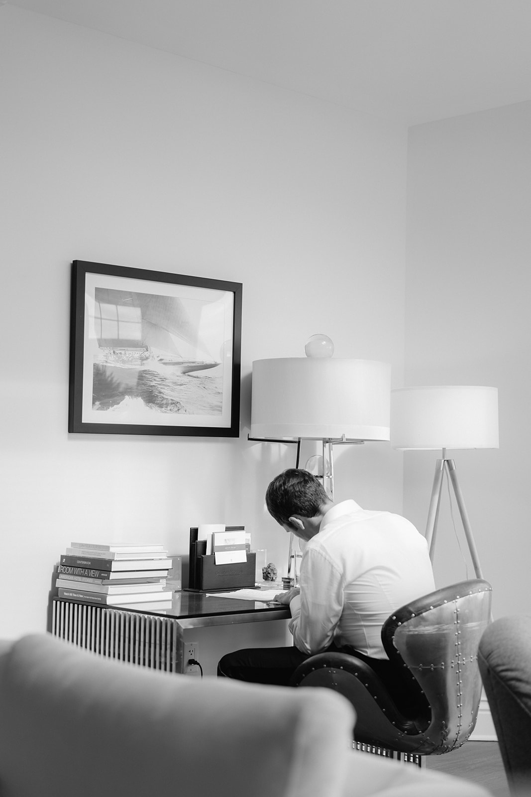 A groom sitting at a desk at Ocean House in Rhode Island writing to his bride. 