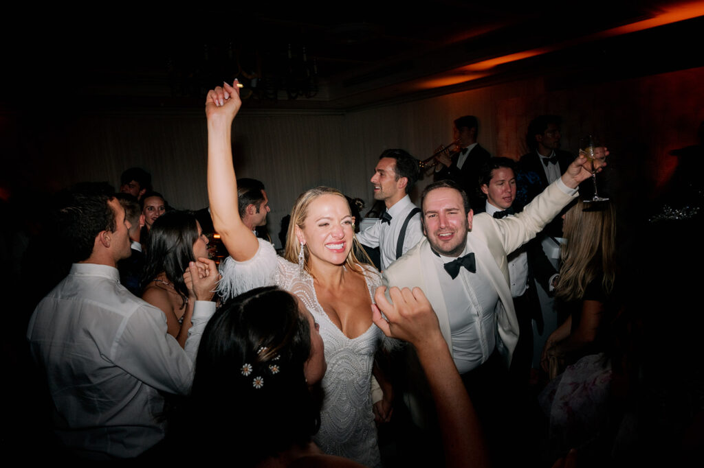 Flash photo of a bride dancing with her guests during the reception dance party.