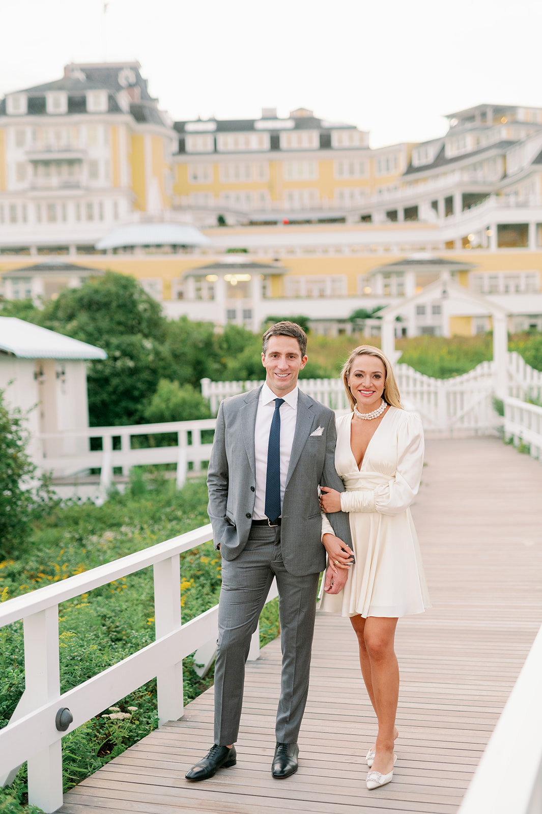 A stylish bride and groom posing outside Ocean House in Rhode Island for their romantic, beachfront rehearsal dinner. 