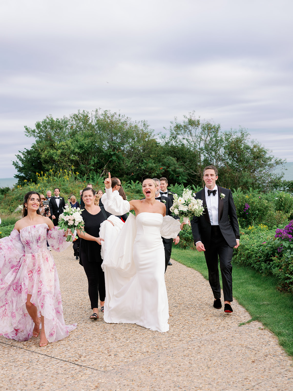 Candid shot of a wedding party walking in the garden of Ocean House  in Rhode Island. 