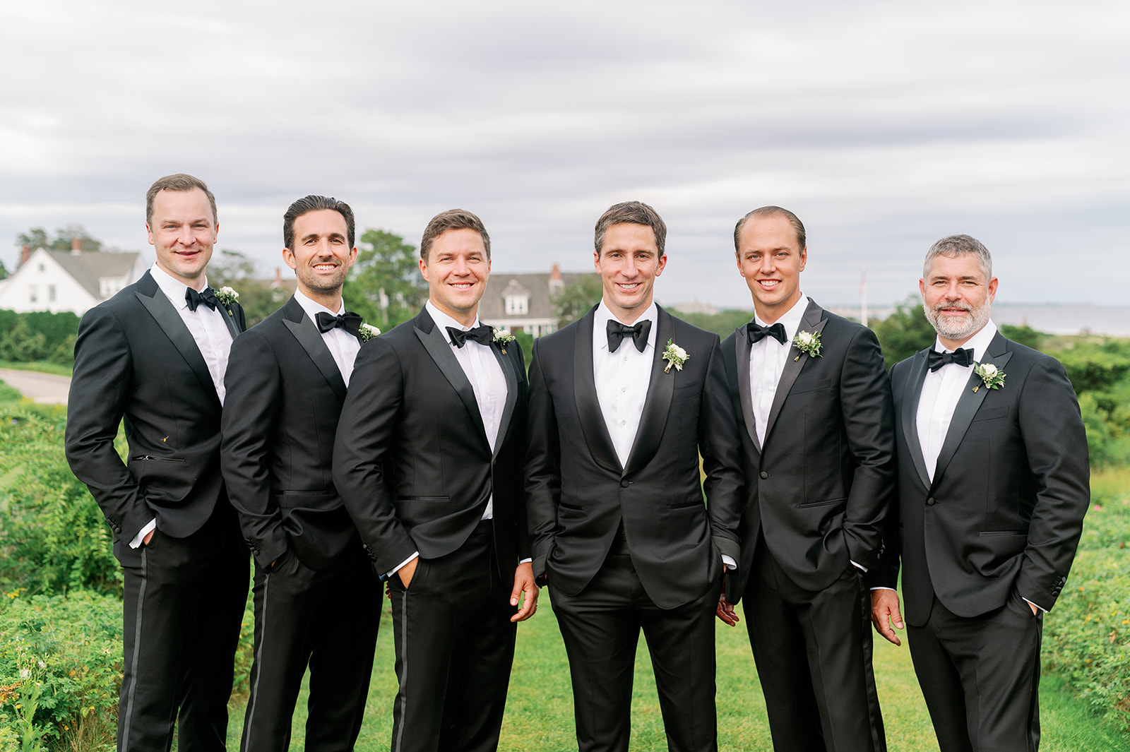Posed groomsmen portrait with classic black suits and bowties. 