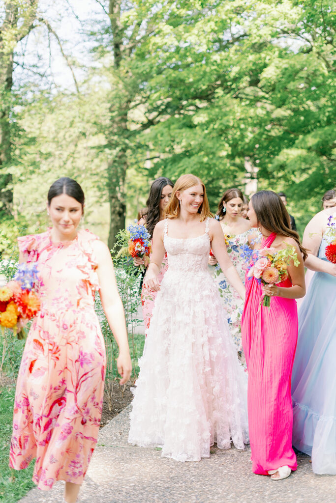 Colorful floral bridal party walking to the outdoor ceremony.