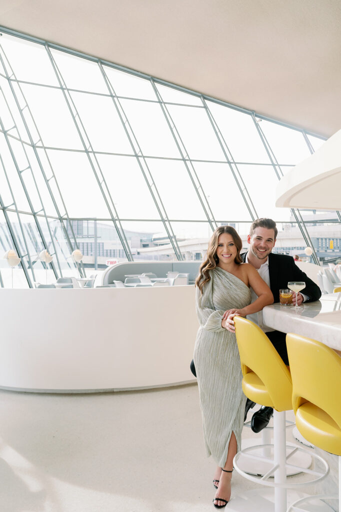 Couple posing at the Paris Cafe bar in the TWA Hotel.