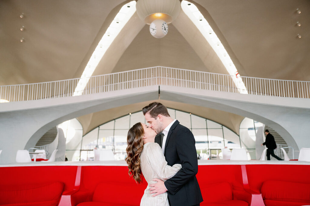 Couple kissing in the lobby of TWA Hotel in New York.