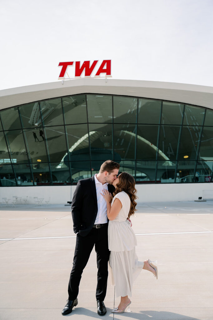 Couple kissing on the TWA Hotel tarmac.