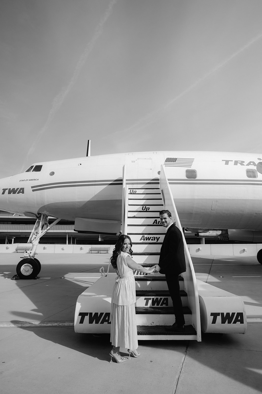 Engagement photos on the steps of the vintage Connie Aircraft at TWA Hotel.
