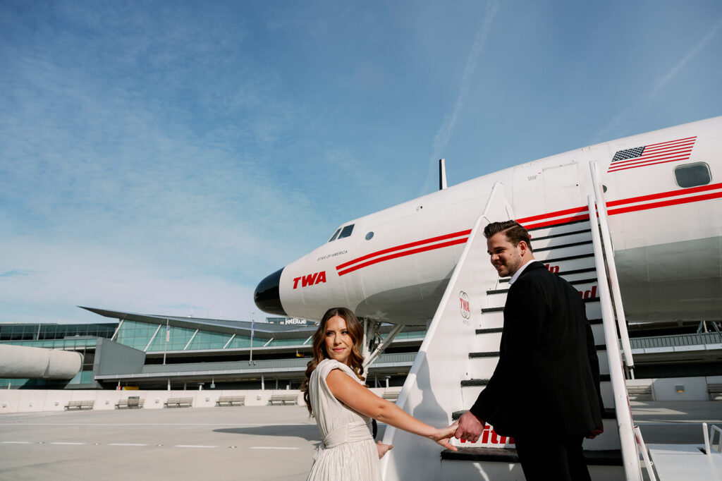Couple walking up the stairs of the vintage Connie Aircraft at TWA Hotel.