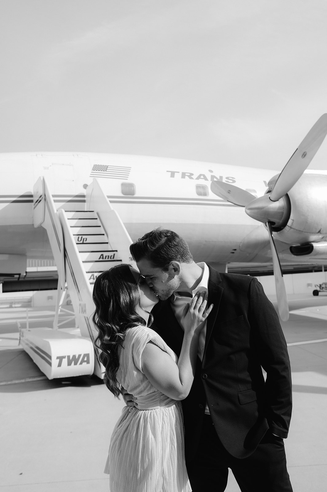 Black and white fine art engagement photo outside the TWA Hotel vintage Connie Aircraft.