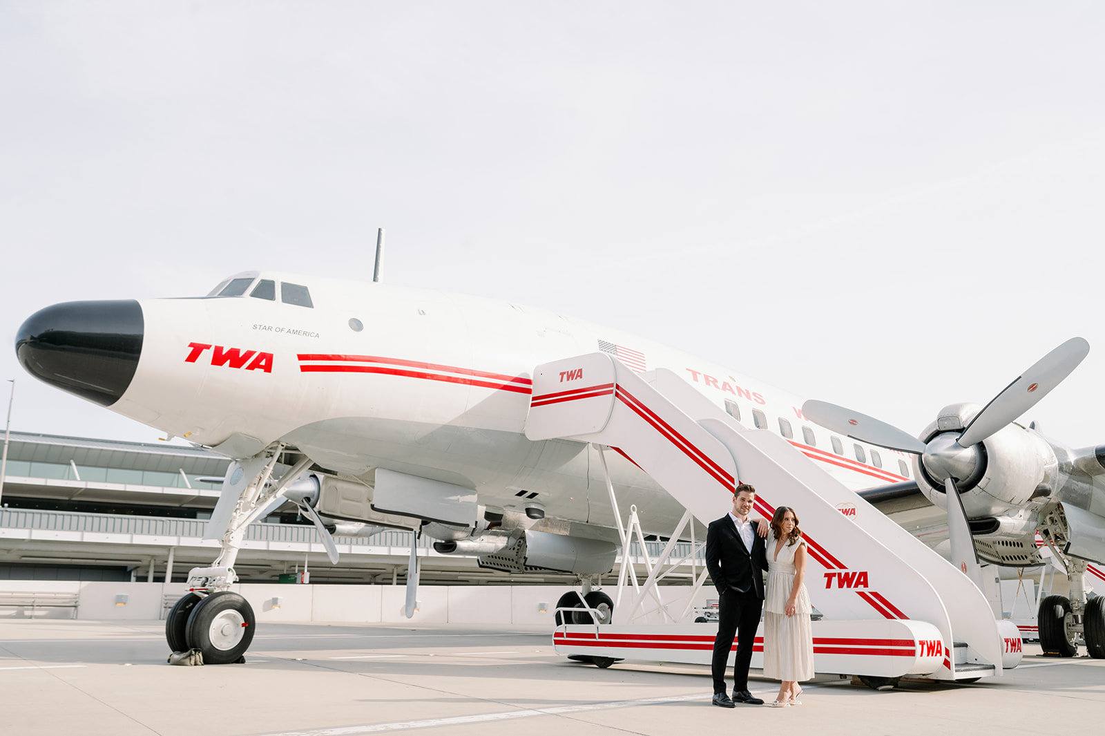 TWA Hotel engagement photos next to the vintage Connie Aircraft.