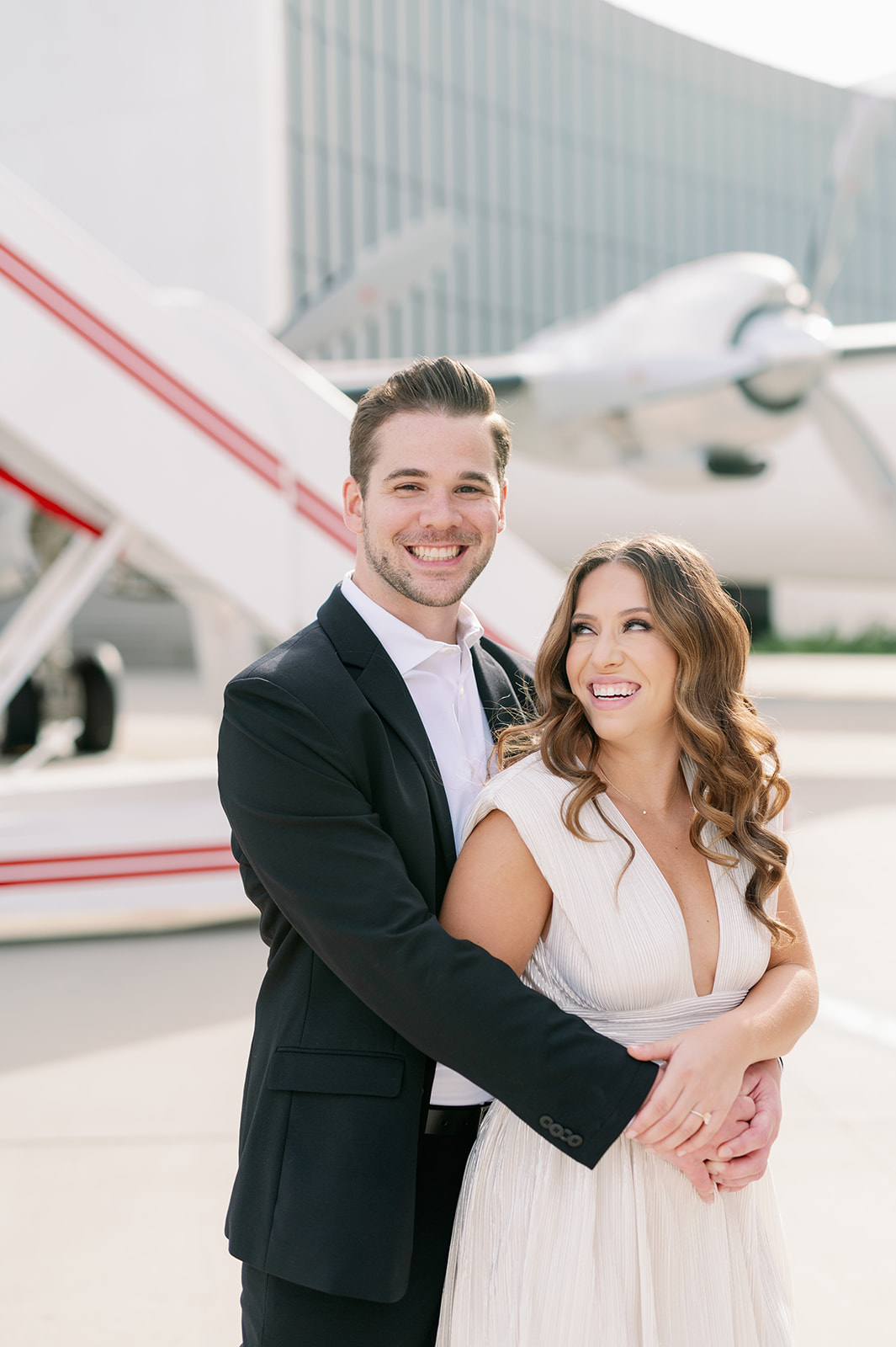 Couple posing for their engagement photos at the TWA Hotel tarmac.