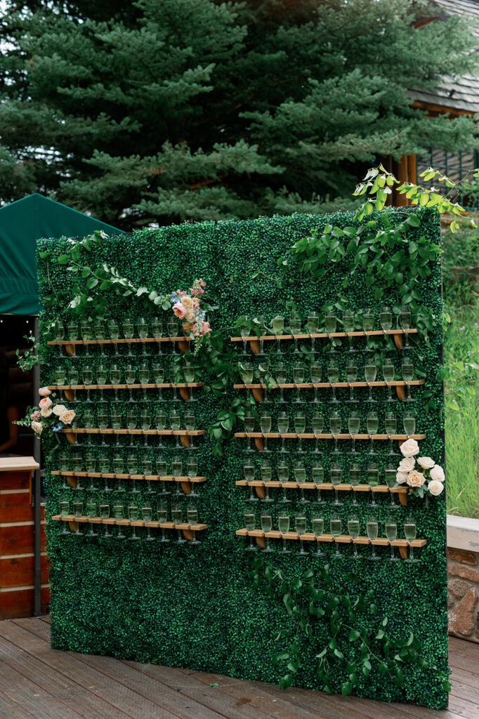 Wedding ceremony champagne greenery wall.