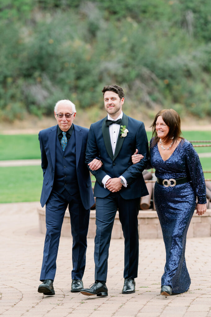 Groom walking with his parents down the aisle during this Sun Valley, Idaho wedding.