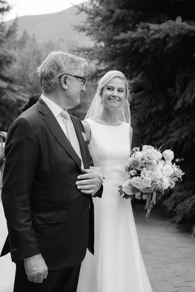 Candid black and white portrait of a bride and her dad right before walking down the aisle.