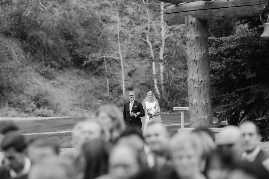 Bride walking down the aisle during this Sun Valley, Idaho wedding at Trail Creek Cabin.