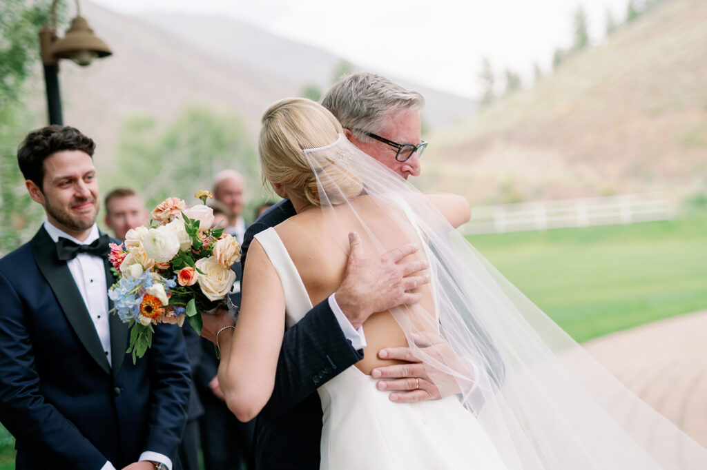 Bride hugging her dad at the altar after walking down the aisle.
