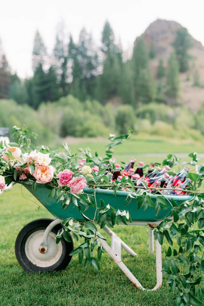 Green wagon filled with flowers and Coke bottles at this Sun Valley, Idaho wedding cocktail hour. 