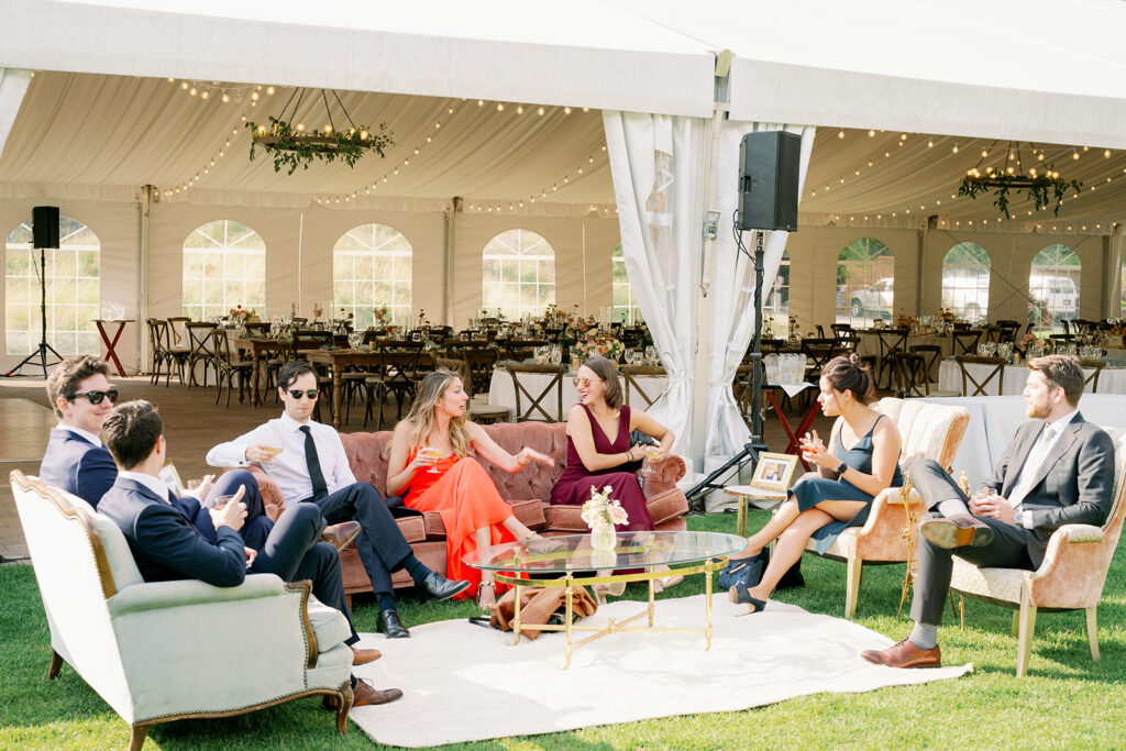 Casual cocktail hour with vintage furniture and tented reception.