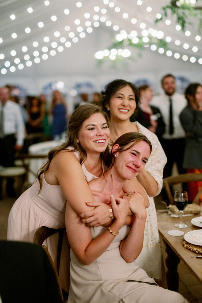 Bridesmaids huddled together getting emotional during first dances.