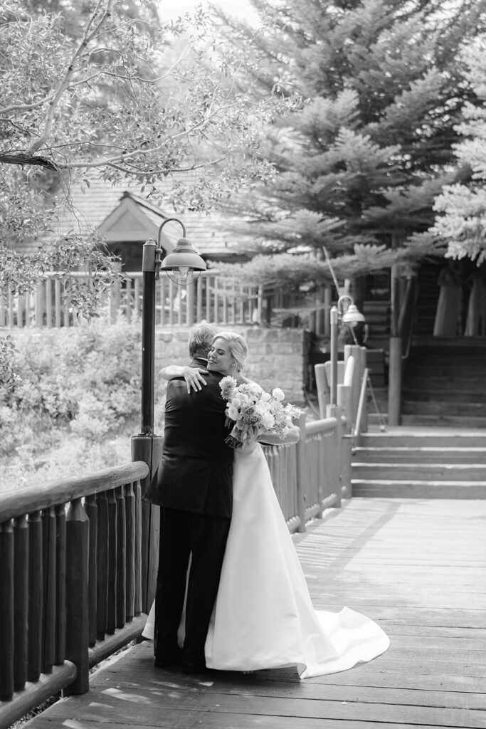 Bride and her dad hugging on a bridge at Trail Creek Cabin wedding in Sun Valley, Idaho.
