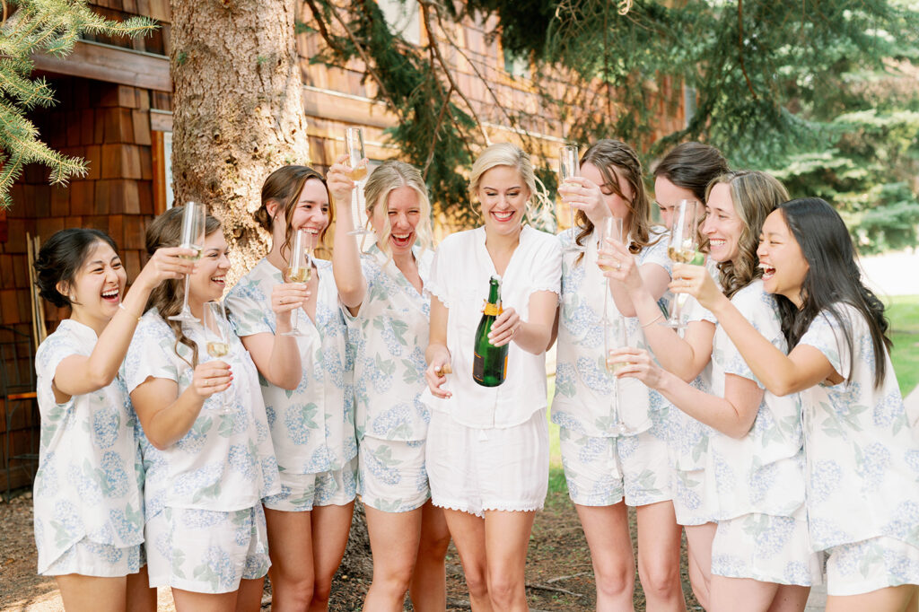 A bridal party champagne pop in Sun Valley, Idaho at Trail Creek Cabin.