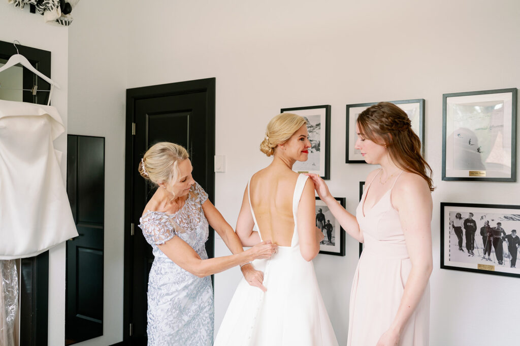 Bride getting her Sareh Nouri’s Dakota wedding dress zipped up by her mom.