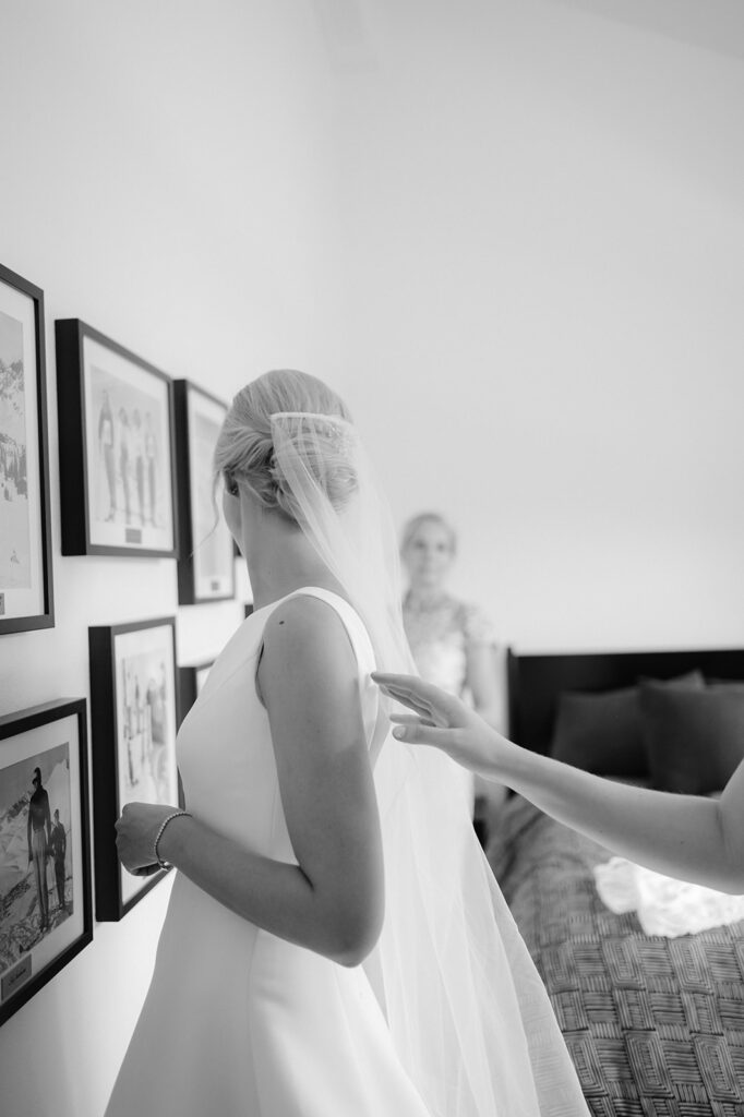 Candid photo of a bride looking back at her mom in the bridal suite.