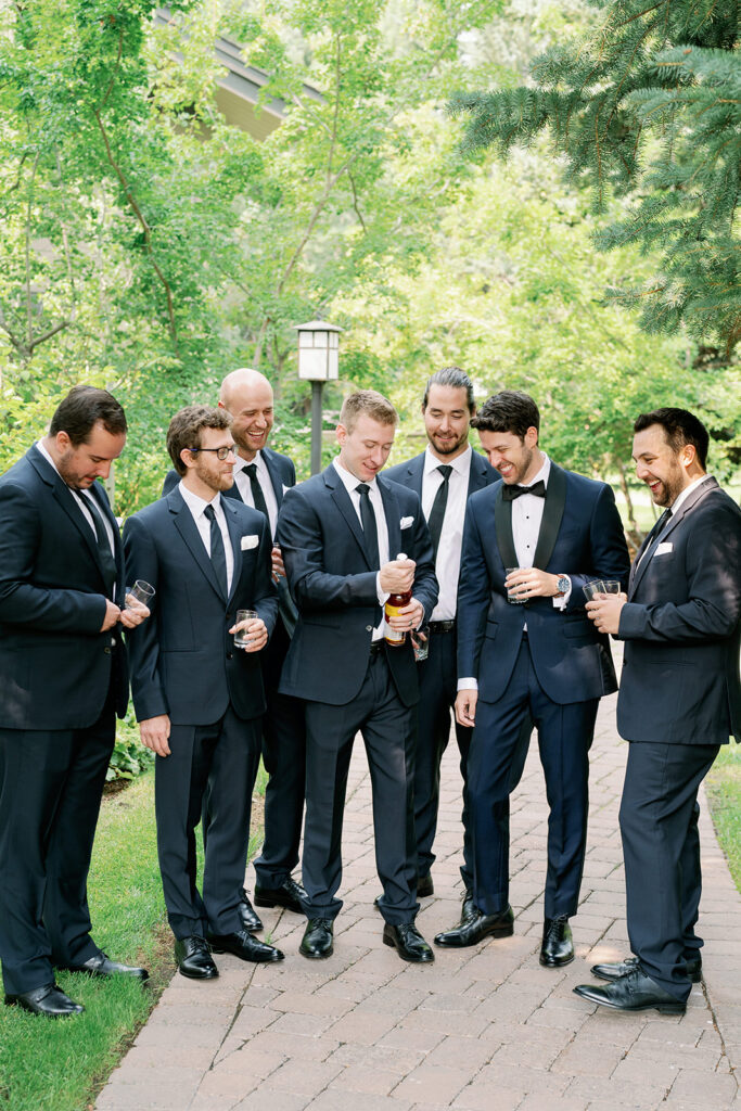 Groom and groomsmen opening a bottle of liqour.